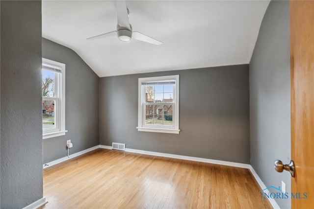 bonus room with light wood-type flooring, vaulted ceiling, a wealth of natural light, and ceiling fan