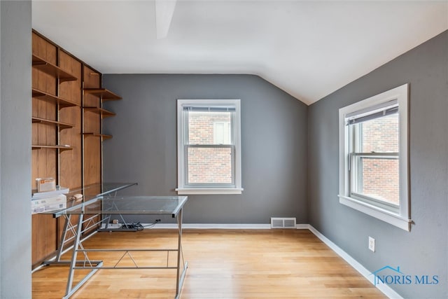 unfurnished office featuring light hardwood / wood-style flooring and vaulted ceiling