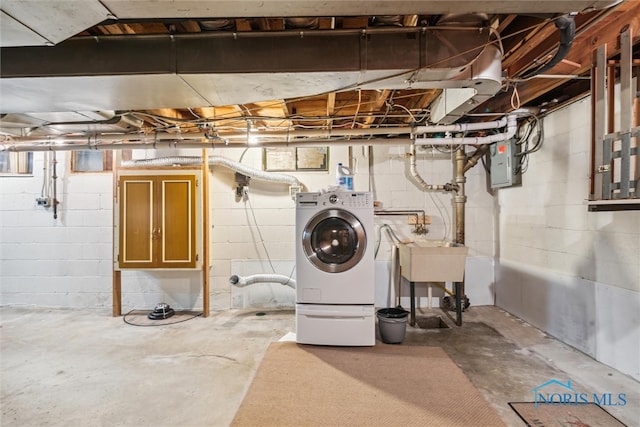 basement with electric panel, sink, and washer / dryer