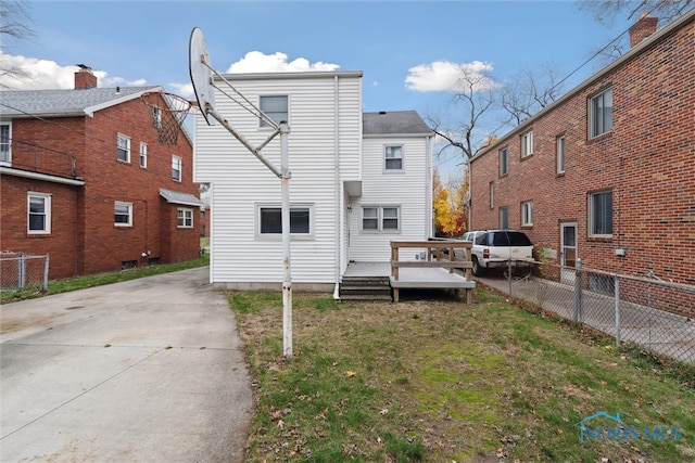 rear view of property with a lawn and a wooden deck