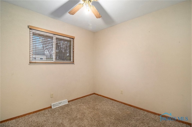 unfurnished room with ceiling fan and carpet