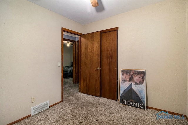 carpeted spare room with ceiling fan