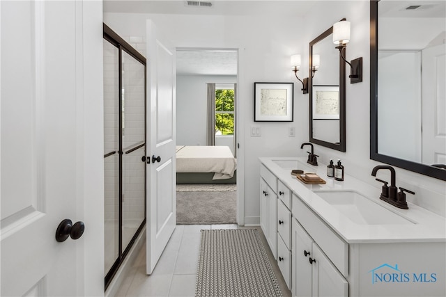 bathroom with tile patterned flooring, vanity, and an enclosed shower