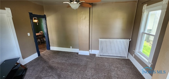 carpeted spare room with ceiling fan and radiator heating unit