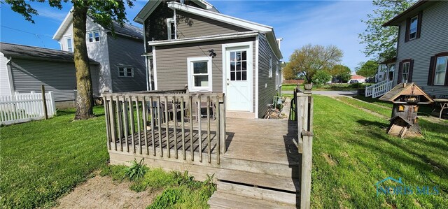 rear view of property with a yard and a wooden deck