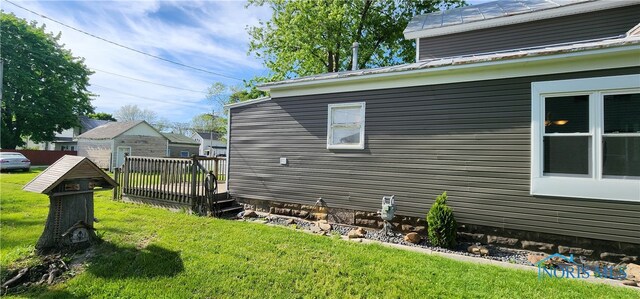 view of home's exterior featuring a deck and a lawn