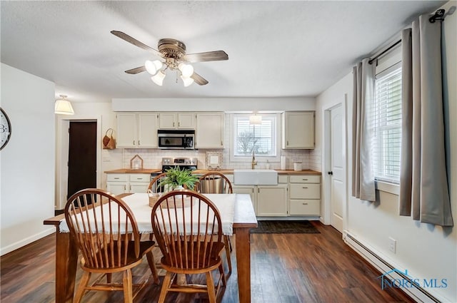 kitchen with sink, stainless steel appliances, decorative backsplash, and baseboard heating