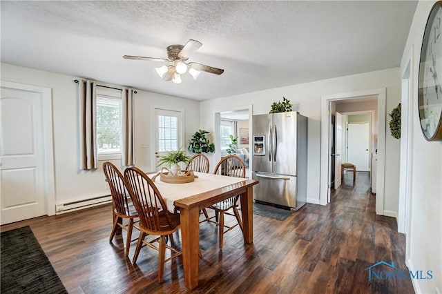 dining space with ceiling fan, dark wood-type flooring, a baseboard radiator, and a textured ceiling