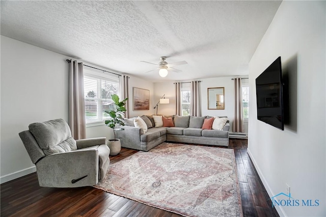 living room featuring ceiling fan, dark wood-type flooring, a textured ceiling, and baseboard heating