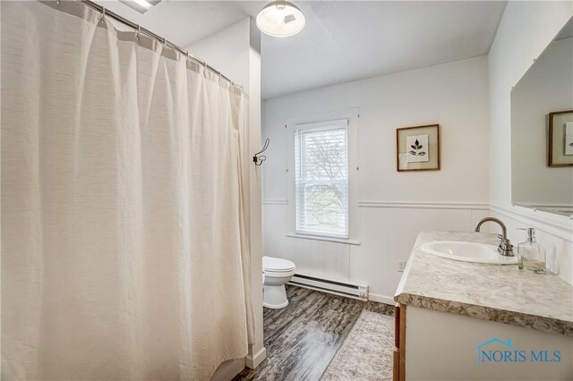 bathroom featuring toilet, a baseboard heating unit, wood-type flooring, and vanity