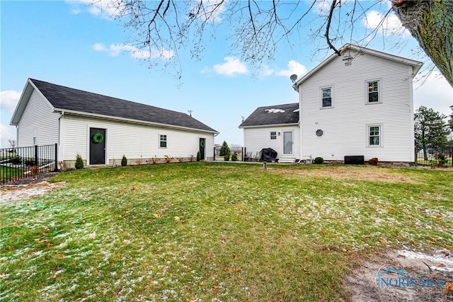 back of house featuring cooling unit and a lawn