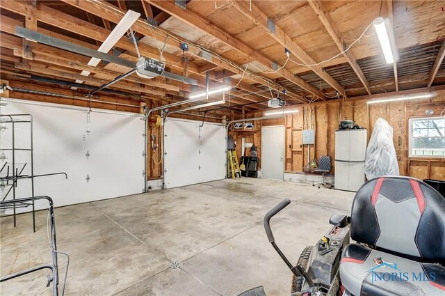 garage featuring white fridge and a garage door opener