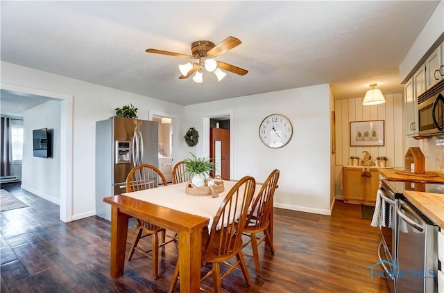 dining room featuring baseboard heating, ceiling fan, and dark wood-type flooring