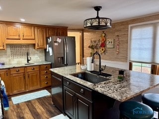 kitchen with appliances with stainless steel finishes, an island with sink, dark hardwood / wood-style floors, and sink