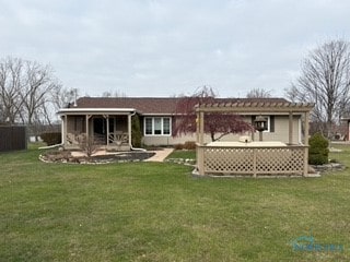 back of house featuring a lawn, a pergola, and a patio