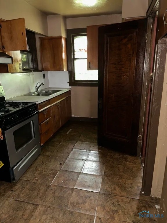 kitchen featuring gas range, extractor fan, and sink