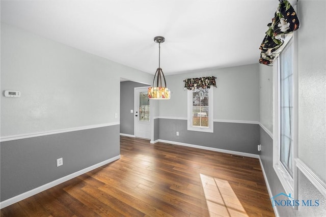 unfurnished dining area featuring dark wood-type flooring