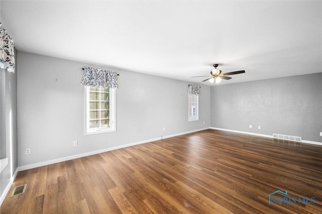 unfurnished room with a wealth of natural light, ceiling fan, and hardwood / wood-style flooring