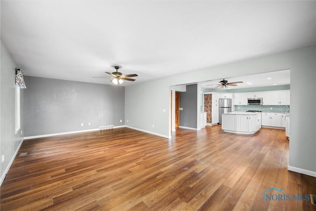 unfurnished living room with ceiling fan and light hardwood / wood-style flooring