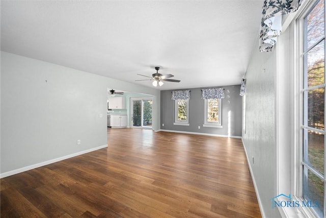 unfurnished living room with ceiling fan and dark wood-type flooring