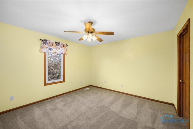 carpeted spare room with ceiling fan