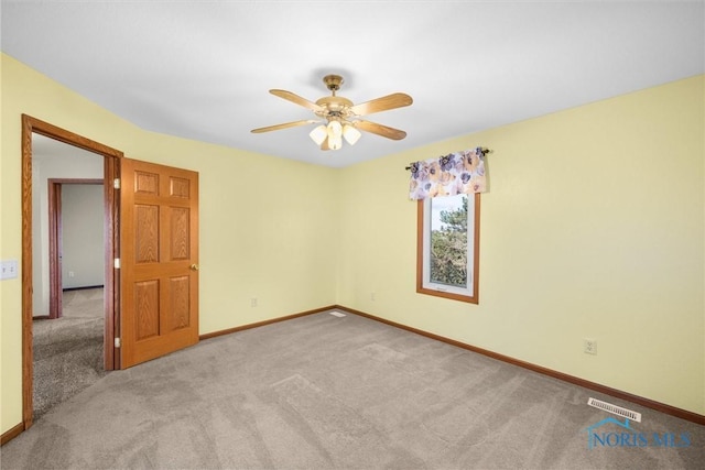 empty room featuring ceiling fan and light carpet