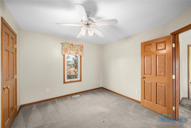 spare room with ceiling fan and carpet