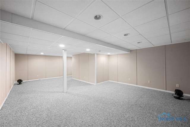 basement featuring a paneled ceiling and carpet floors