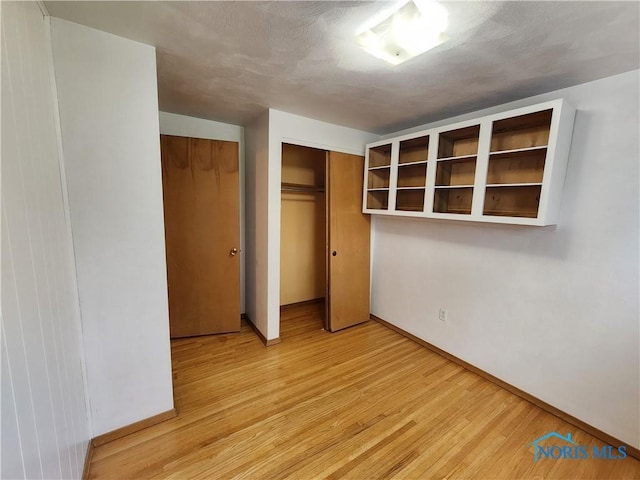 unfurnished bedroom with light wood-type flooring and a closet