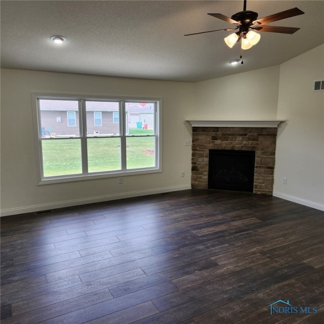 unfurnished living room featuring ceiling fan, dark hardwood / wood-style flooring, and a textured ceiling