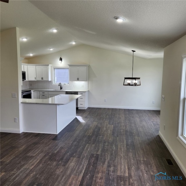 kitchen featuring lofted ceiling, hanging light fixtures, dark hardwood / wood-style floors, decorative backsplash, and white cabinetry