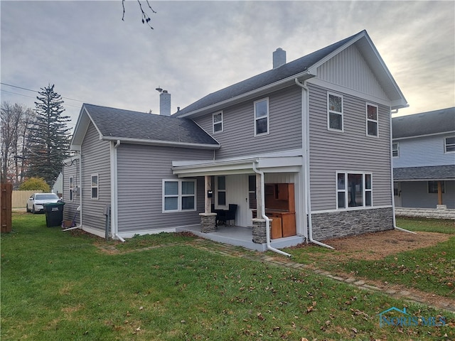 rear view of house featuring a lawn