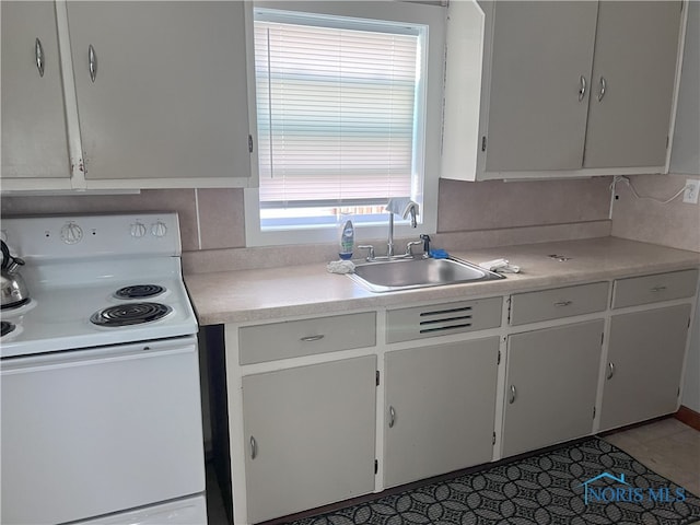 kitchen featuring backsplash, sink, electric range, tile patterned flooring, and white cabinetry