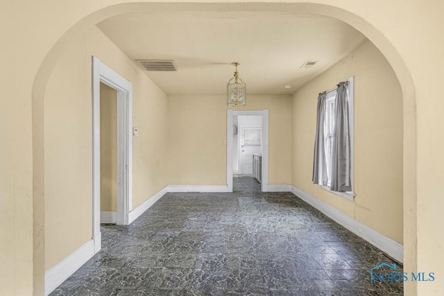 empty room featuring a notable chandelier