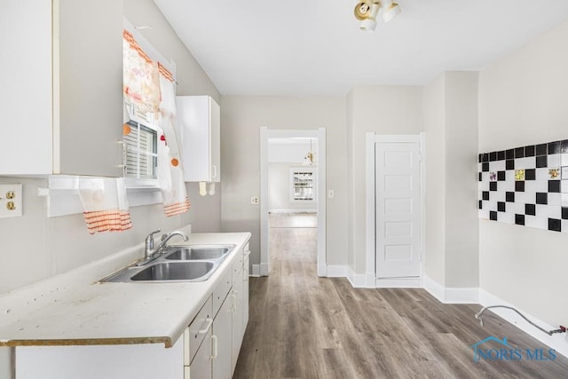 kitchen with white cabinetry, sink, and light hardwood / wood-style floors