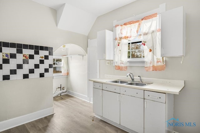 kitchen featuring white cabinetry, sink, and light hardwood / wood-style floors