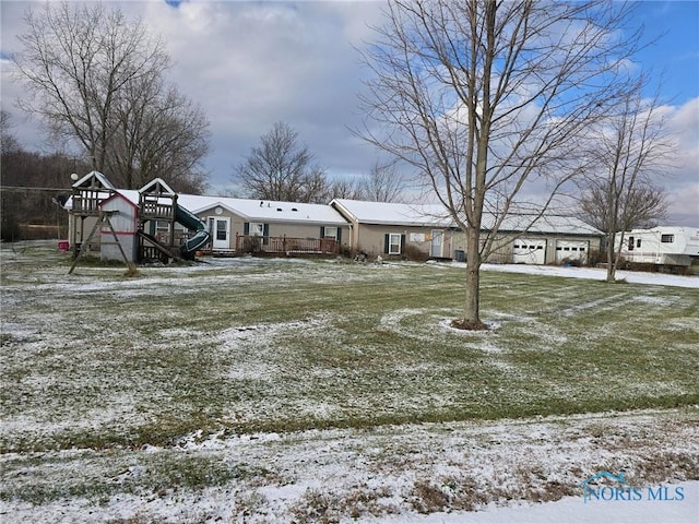 yard covered in snow featuring a playground