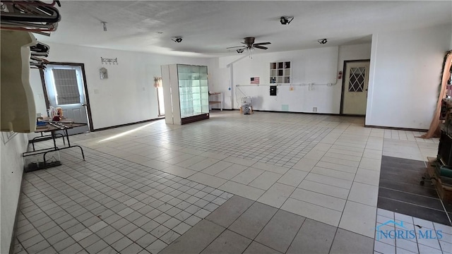 unfurnished living room featuring light tile patterned floors and ceiling fan