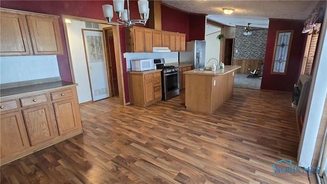 kitchen with sink, a notable chandelier, lofted ceiling, a center island with sink, and appliances with stainless steel finishes