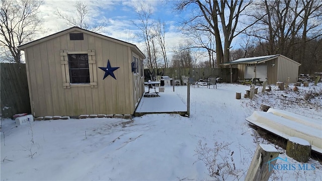 snowy yard featuring a storage shed