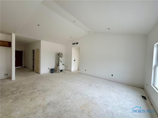 unfurnished room with vaulted ceiling