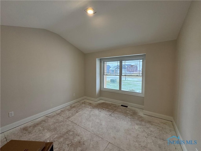 spare room featuring lofted ceiling