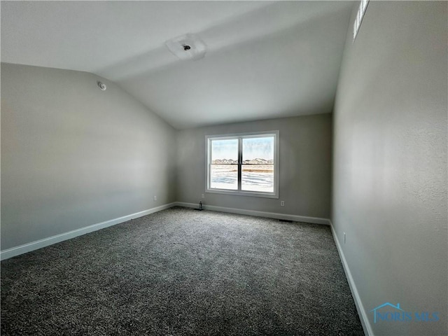 unfurnished room with vaulted ceiling and carpet