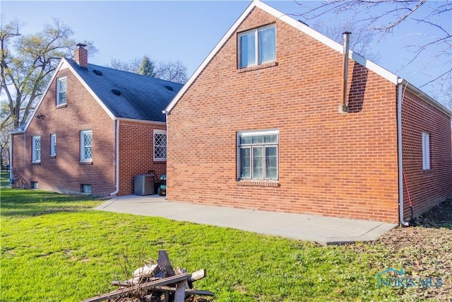 back of house featuring a patio area, a yard, and central AC