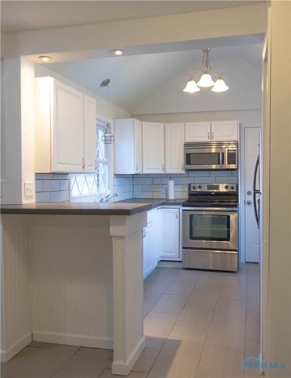 kitchen featuring kitchen peninsula, white cabinets, lofted ceiling, and appliances with stainless steel finishes