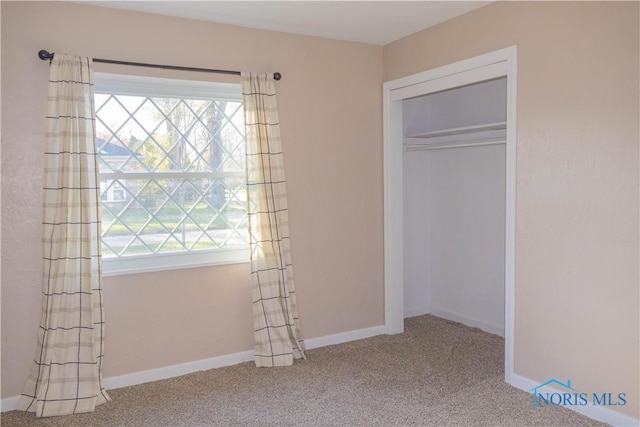 unfurnished bedroom with carpet flooring and a closet