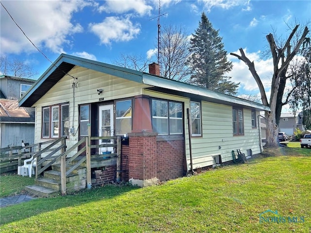 bungalow-style home featuring a front lawn