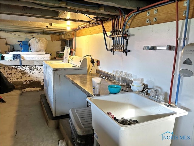 basement featuring independent washer and dryer and sink