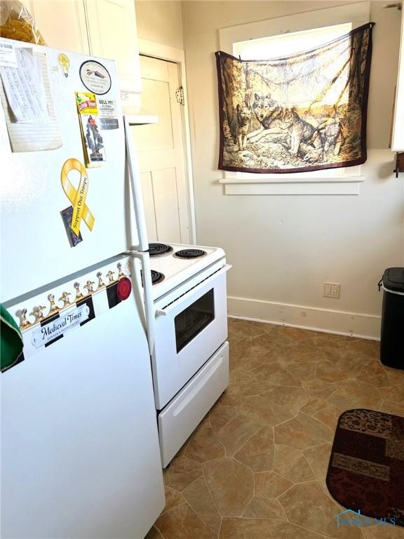 kitchen with white cabinets, white appliances, and tile patterned floors