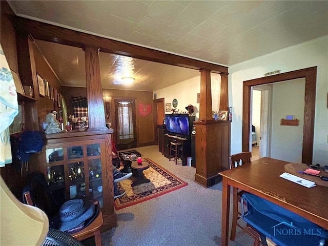 carpeted living room with decorative columns